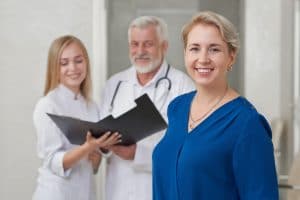 Happy patient and doctors posing, smiling
